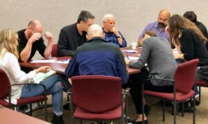 9 people sitting around table doing idea tree exercise